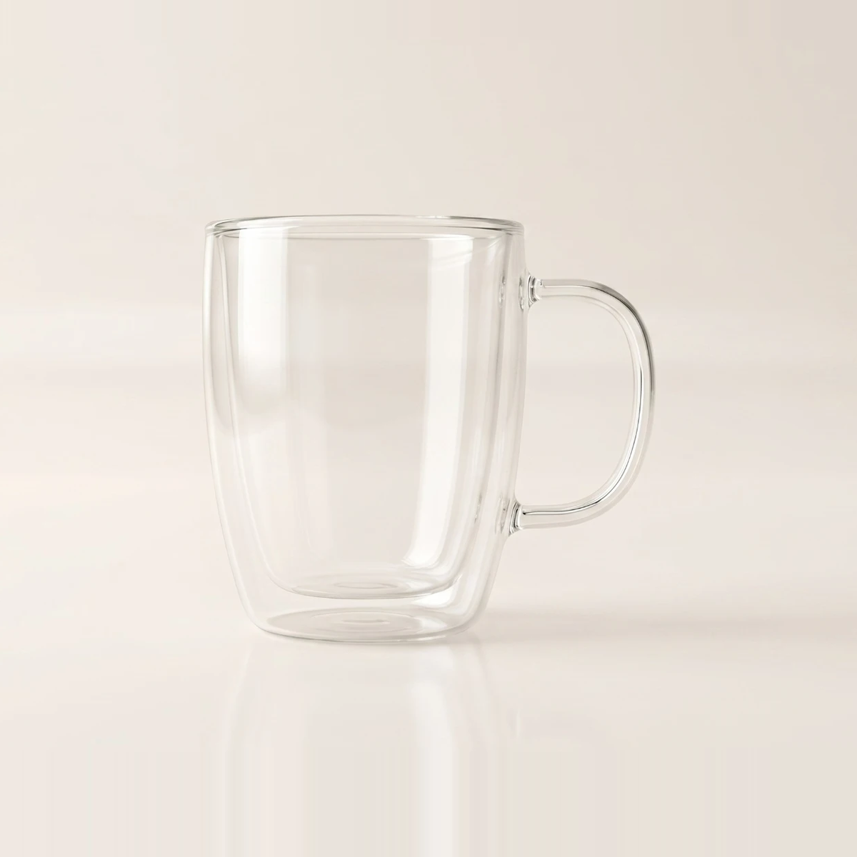 Clear double-walled glass mug with a smooth drawn handle, the inner wall visible through the body