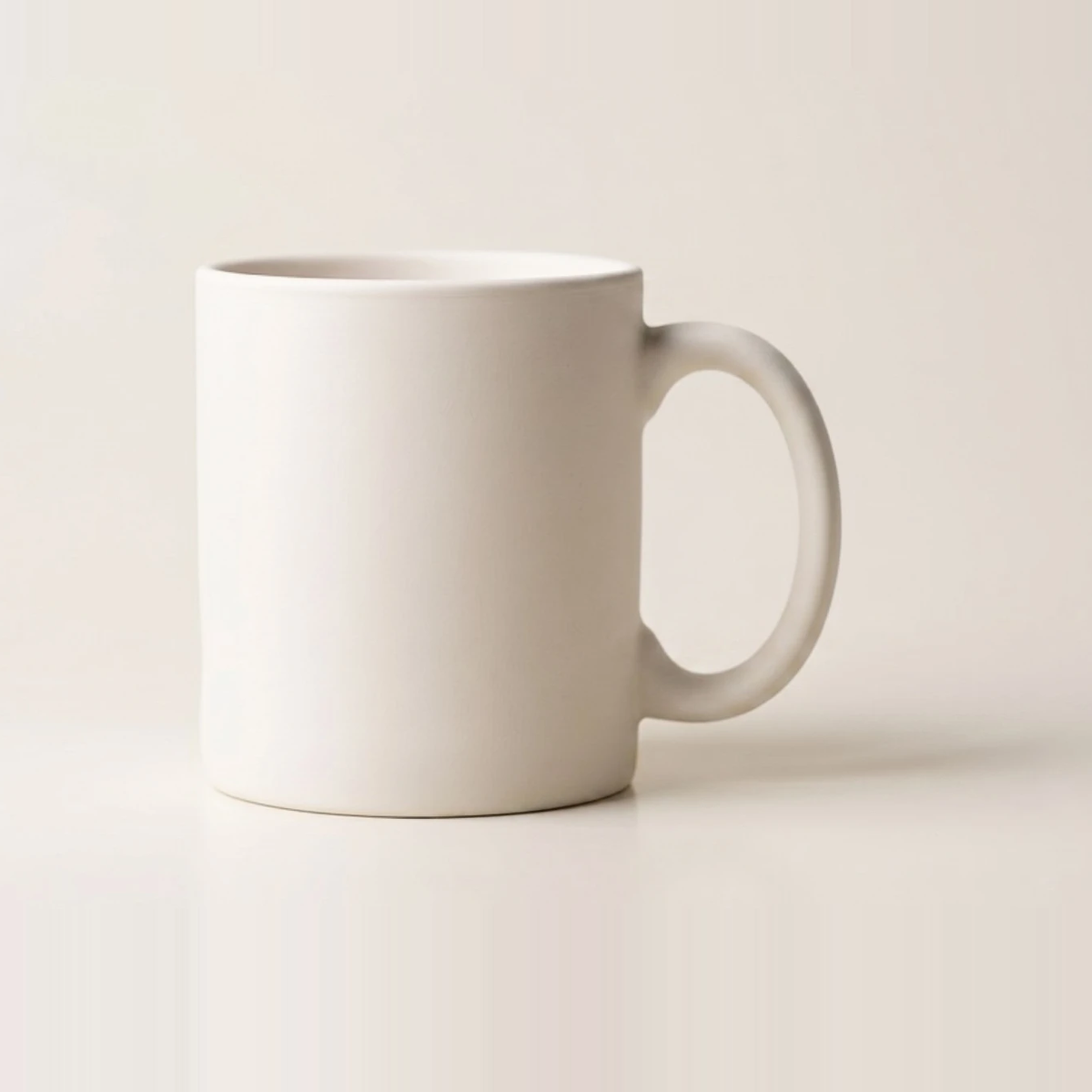 Straight-sided porcelain mug in a bright, even off-white finish with a slim pulled handle