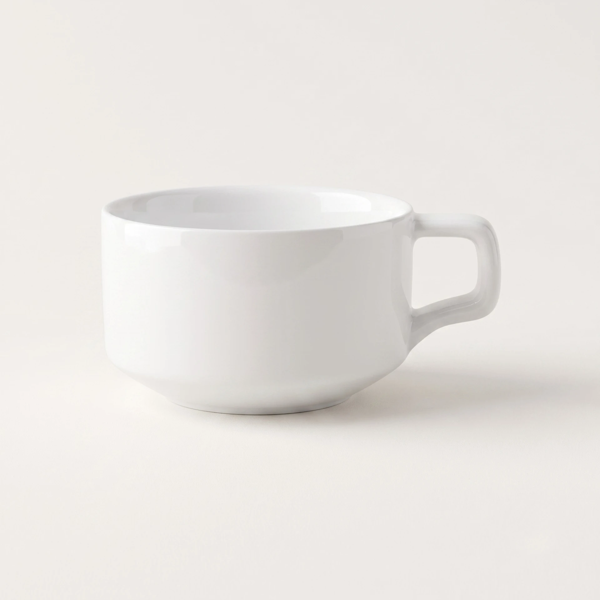 Low, wide white porcelain cup with a squared handle