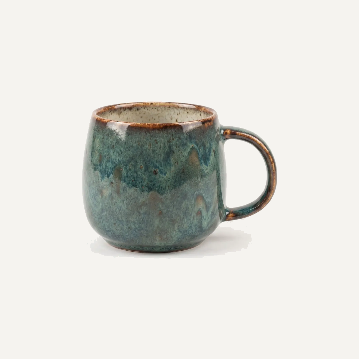 Mug in a deep teal reactive glaze that breaks to rust brown over the rim and pools darker down the body, so the colour shifts across the piece